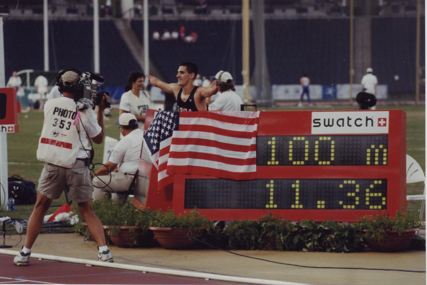 Scoreboard reading 100m 11.36 as Tony Volpentest celebrates